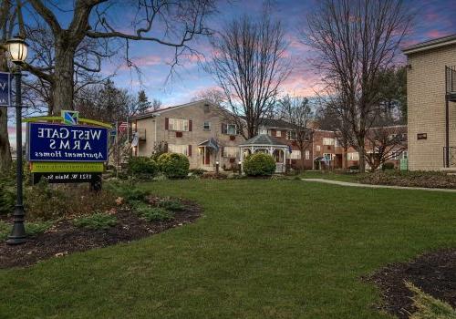 Evening view of the West Gate Arms apartment community 在Jeffersonville, with warm lights illuminating the courtyard